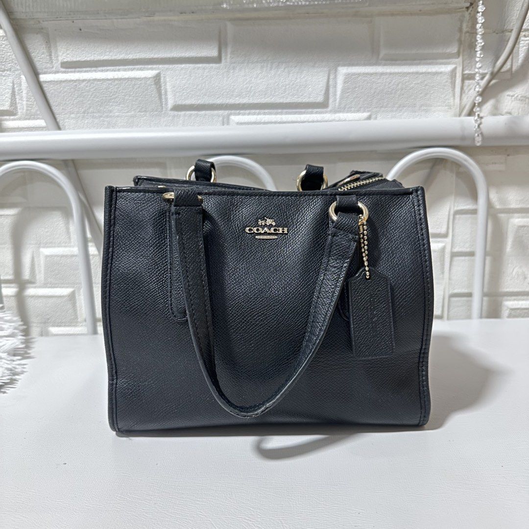 Coach Black Leather Satchel Handbag (Category: Luxury Bags & Wallets) located in Marikina City. Submitted by bry_lei26 (Listing ID 1468585419, Image 1). Description: - Brand: Coach - Style: Black pebbled leather tote bag - Hardware: Gold-tone - Features: Double top handles, matching leather hangtag, secure top zipper closure, lined interior - Condition: Clean inside and out with minor wear on hardware and handles from previous use -slight shrink 