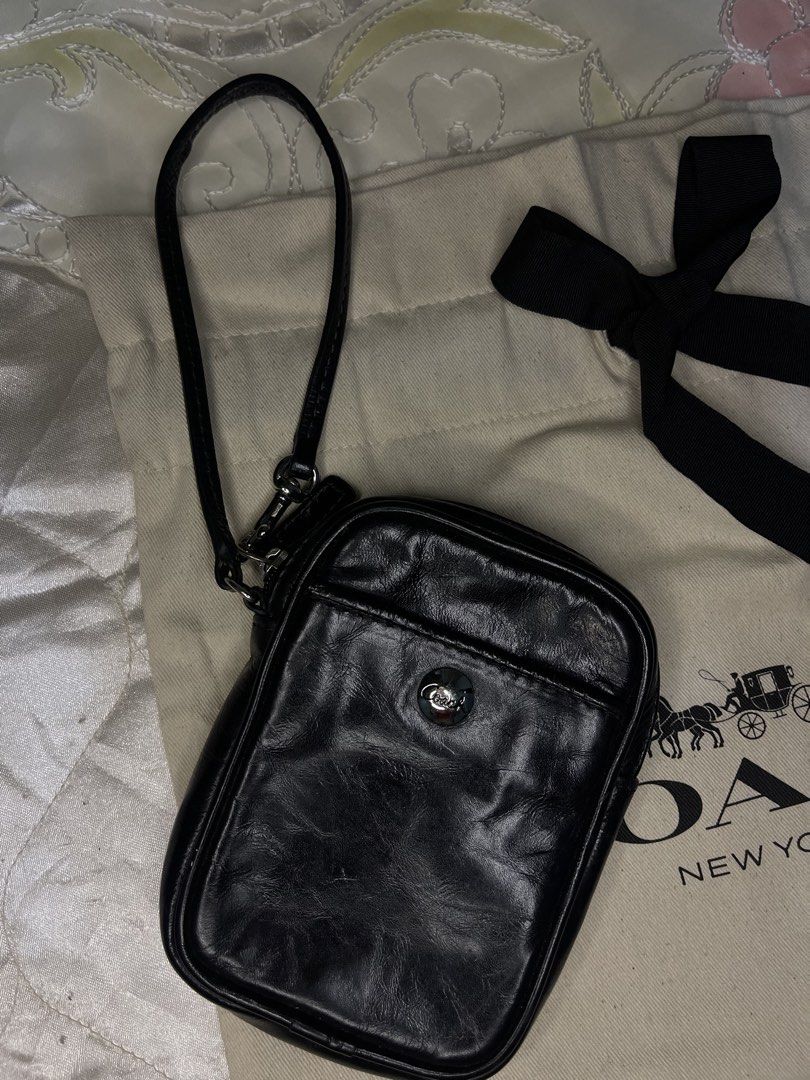 Coach Black Leather Wristlet Pouch (Category: Purses & Pouches) located in Dumaguete. Submitted by braveforest-2a12 (Listing ID 1468647971, Image 2). Description: - Authentic Coach black leather wristlet pouch - Secure zip top closure with convenient wrist strap - Front slip pocket accented with a silver Coach button - Roomy interior fits cards, keys, and small essentials - Includes original dust bag with attached black ribbon.