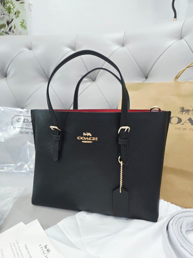 Coach Black Tote Bag with Red Interior (Category: Tote Bags) located in Marikina City. Submitted by jemalynpdc77 (Listing ID 1468584854, Image 2). Description: M0IIiE Tote Bag Ready to Ship 😍 Complete Inclusions 3-way tote bag (with extra straps) Measurements Length: 9.75" Height: 7.5" Width: 4.75" Materials Double face leather and polished pebble leather Fabric lining Handle Handles with 4.75" drop Strap Detachable strap with 22" drop for shoul