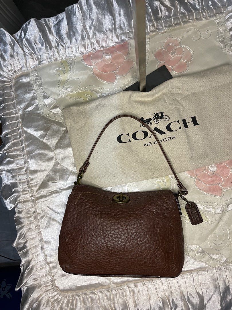 Coach Choco Brown mini turnlock (Category: Luxury Bags & Wallets) located in Dumaguete. Submitted by braveforest-2a12 (Listing ID 1468647807, Image 1). Description: - Brand: Coach - Material: Premium brown pebbled leather - Hardware: Classic brass-tone - Closure: Secure turnlock closure - Strap: Single shoulder strap - Interior: Clean dark fabric lining with a slip pocket - Structure: Firm and structured base - Inclusions: Original dust bag and l