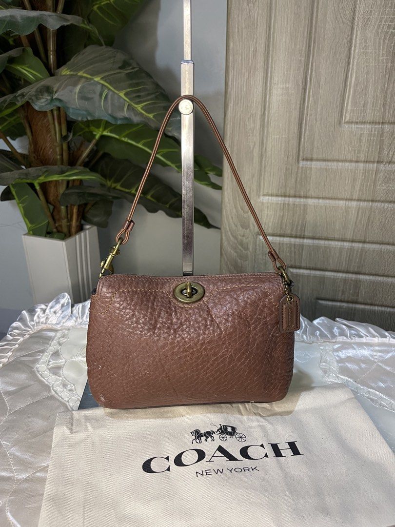 Coach Choco Brown mini turnlock (Category: Luxury Bags & Wallets) located in Dumaguete. Submitted by braveforest-2a12 (Listing ID 1468647807, Image 2). Description: - Brand: Coach - Material: Premium brown pebbled leather - Hardware: Classic brass-tone - Closure: Secure turnlock closure - Strap: Single shoulder strap - Interior: Clean dark fabric lining with a slip pocket - Structure: Firm and structured base - Inclusions: Original dust bag and l
