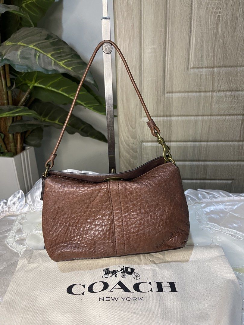 Coach Choco Brown mini turnlock (Category: Luxury Bags & Wallets) located in Dumaguete. Submitted by braveforest-2a12 (Listing ID 1468647807, Image 3). Description: - Brand: Coach - Material: Premium brown pebbled leather - Hardware: Classic brass-tone - Closure: Secure turnlock closure - Strap: Single shoulder strap - Interior: Clean dark fabric lining with a slip pocket - Structure: Firm and structured base - Inclusions: Original dust bag and l