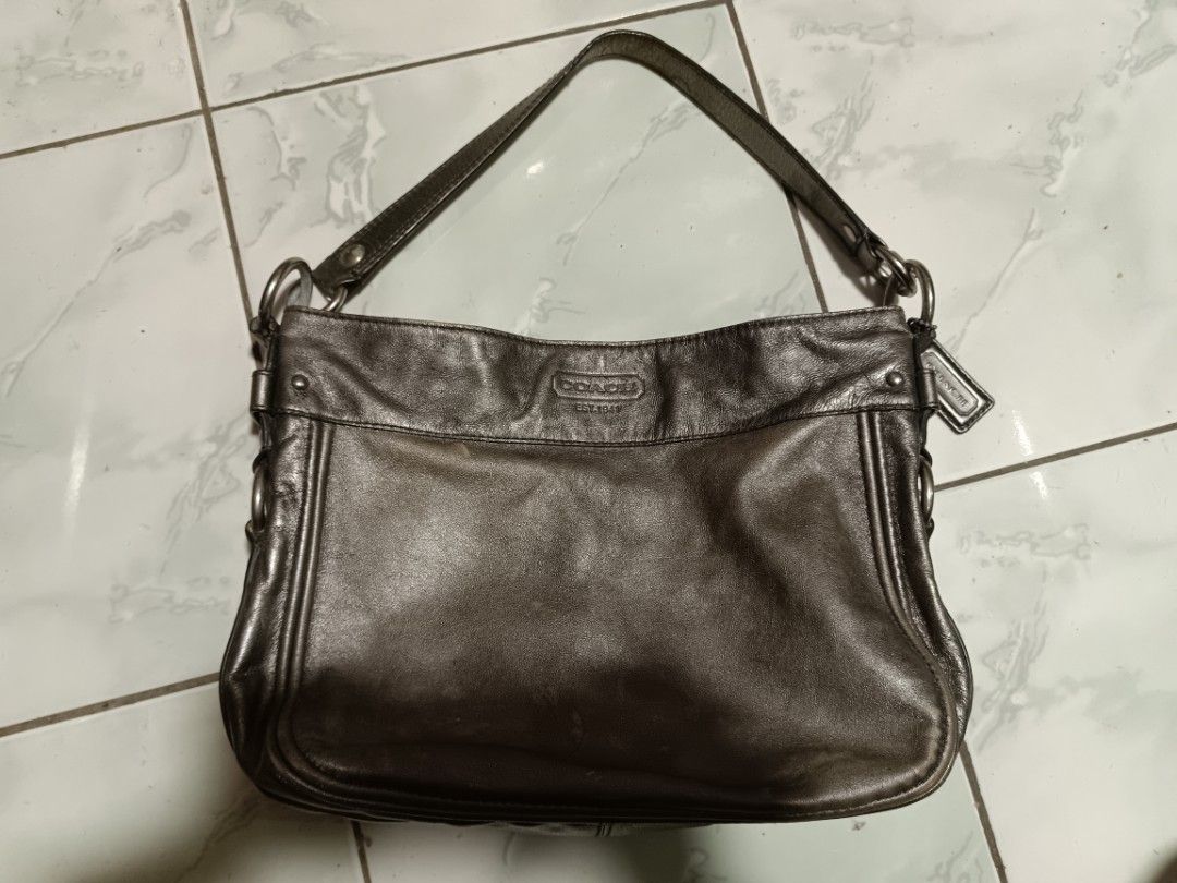 Coach Metallic Bronze Leather Shoulder Bag (Category: Luxury Bags & Wallets) located in Manila. Submitted by caaths_collection (Listing ID 1468669560, Image 2). Description: - Brand: Coach - Material: Metallic bronze leather - Design: Embossed logo on front flap with silver hardware - Features: Single top handle, secure zip top closure, - Condition: Shows some wear along the edges and bottom base - as is.