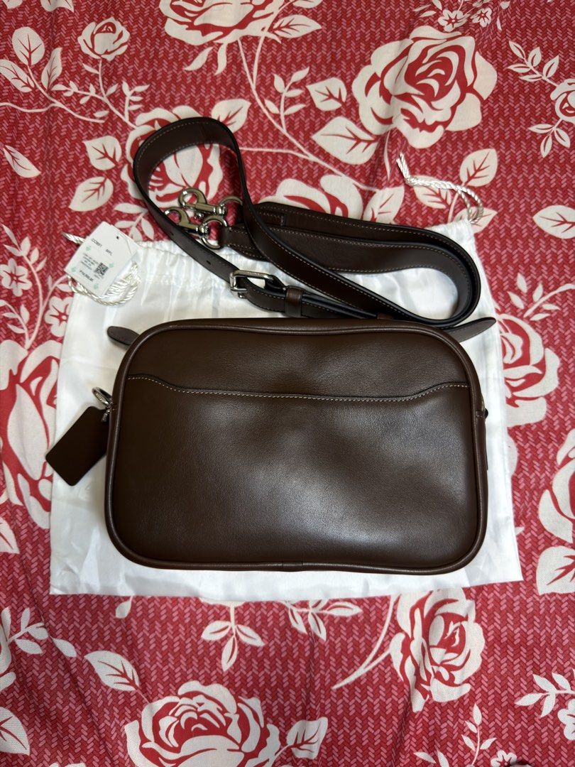 Coach Radio Camera Bag (Category: Luxury Bags & Wallets) located in Mabalacat. Submitted by madsnicdao (Listing ID 1468598412, Image 3). Description: Original price at Php 19,500 Selling at Php 10,000 Maple in Color Natural grain leather Inside snap pocket Zip closure, fabric lining Outside magnetic snap pocket Detachable strap with 55cm drop for shoulder or crossbody wear 23cm (L) x 15cm (H) x 6.5cm (W).