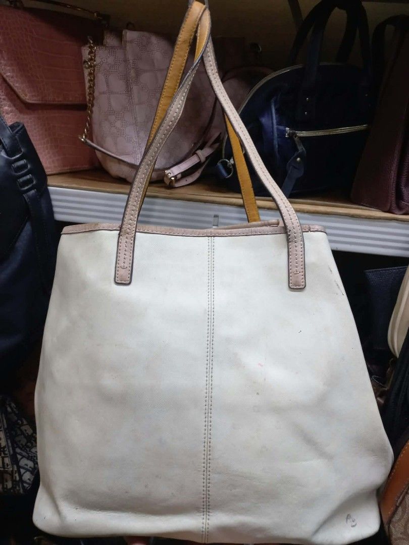 Coach White Tote Bag (Category: Luxury Bags & Wallets) located in Manila. Submitted by dei03_diz (Listing ID 1468692260, Image 2). Description: - Brand: Coach - Style: White canvas tote bag with dual leather shoulder straps - Hardware: Silver-tone - Interior: Fabric lining with 1 zipper pocket and slip pockets - Authenticity: Includes inner leather creed patch with serial number C1380-F24341 - Condition: Overall exterior and interior show visible