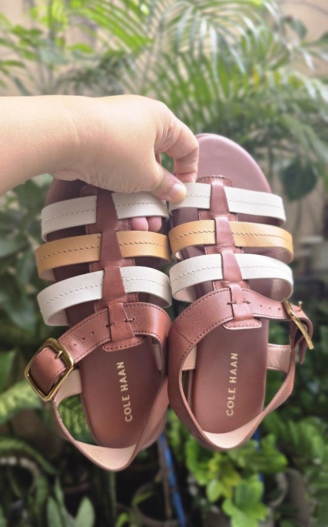 Cole Haan Multi-Color Leather Flat Sandals (Category: Flats & Sandals) located in Quezon City. Submitted by momof3_11 (Listing ID 1468514264, Image 2). Description: - Brand: Cole Haan - Type: Flat sandals - Material: Brown, white, and tan leather straps - Closure: Gold-tone buckle at the ankle - Details: Clean footbeds with embossed gold logo lettering - Condition: Comfortable flat sole with light wear on the bottom tread - Style: Great option fo