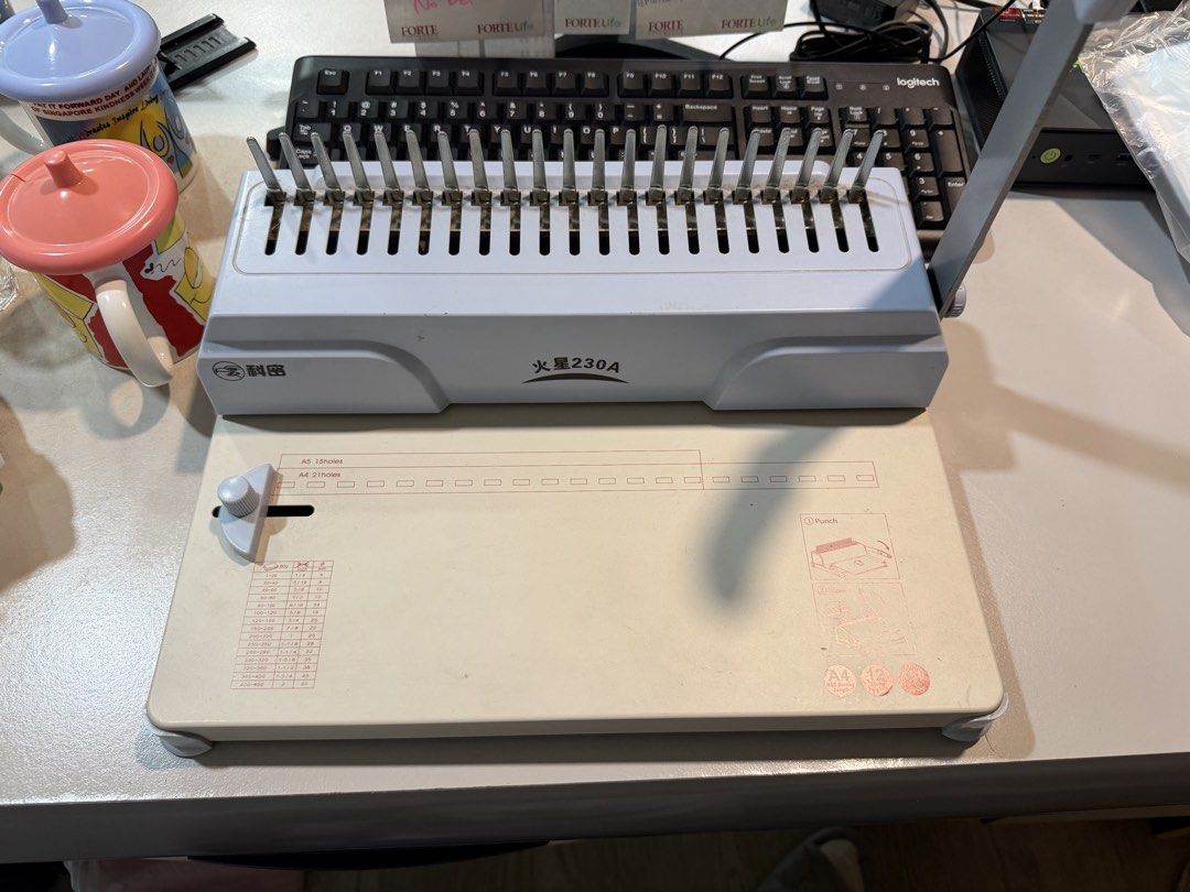 Comb Binding Machine (Category: Craft Supplies & Tools) located in Singapore. Submitted by jay_gao (Listing ID 1468693544, Image 2). Description: - Model: Kelu Xinghuo 230A plastic comb binding machine - Sturdy build with a heavy-duty right-side metal handle - Adjustable margin guide and built-in A4/A5 punching guides - Handy capacity chart printed directly on the front - Ideal for home and office document binding Left with binding paper and comb