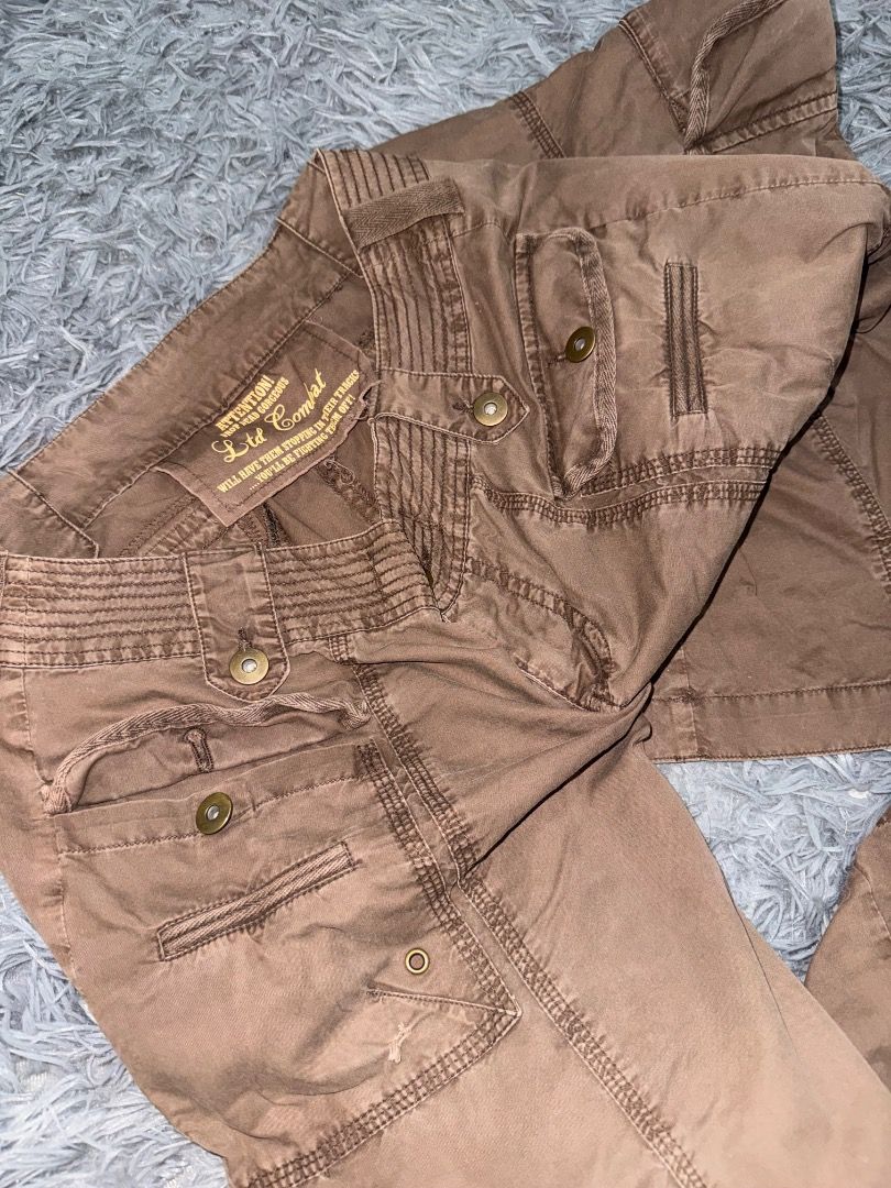 Combat Brown Cargo Y2K (Category: Jeans) located in Quezon City. Submitted by ashhaul (Listing ID 1468570359, Image 3). Description: - Brand/Model: Ltd Combat Brown Cargo Pants - Style: Heavy utility, rugged streetwear, relaxed fit - Pockets: Multiple functional pockets on legs and waist - Details: Button closures, reinforced stitching throughout - Hem: Adjustable zip hems at the ankles - Color: Earthy brown.