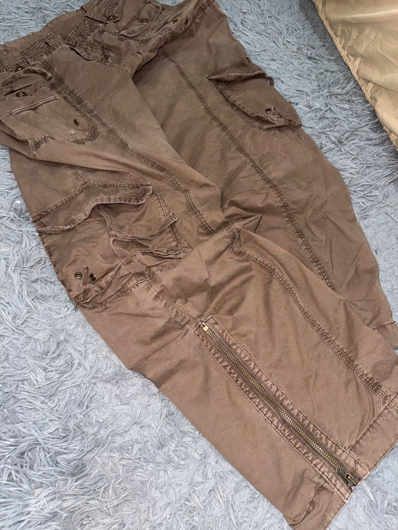Combat Brown Cargo Y2K (Category: Jeans) located in Quezon City. Submitted by ashhaul (Listing ID 1468570359, Image 2). Description: - Brand/Model: Ltd Combat Brown Cargo Pants - Style: Heavy utility, rugged streetwear, relaxed fit - Pockets: Multiple functional pockets on legs and waist - Details: Button closures, reinforced stitching throughout - Hem: Adjustable zip hems at the ankles - Color: Earthy brown.