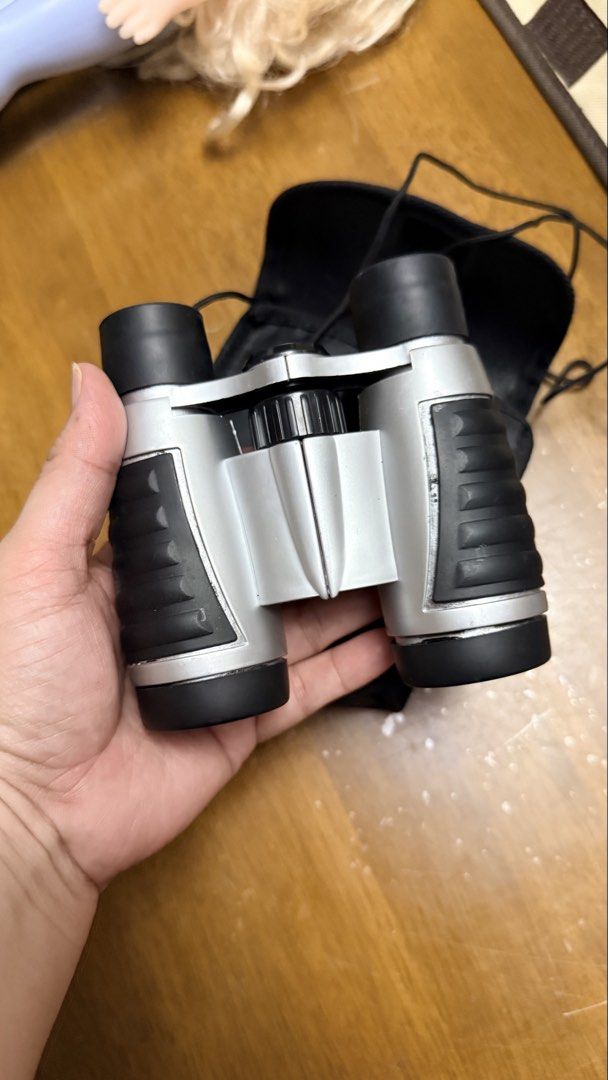 Compact Silver and Black Binoculars with Carrying Pouch (Category: Hiking & Camping) located in Pilar. Submitted by faveanyshop (Listing ID 1468550439, Image 1). Description: - Sleek silver and black compact design - Smooth center focus wheel for easy viewing - Dark blue tinted lenses - Ideal for travel, hiking, and outdoor events - Includes a black fabric carrying pouch and adjustable neck strap.