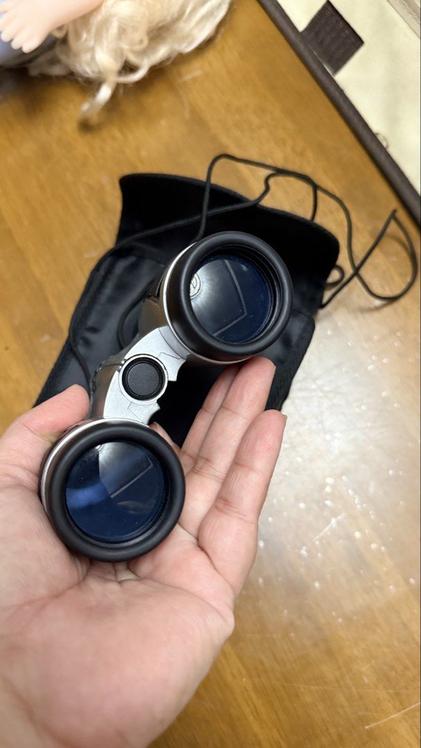 Compact Silver and Black Binoculars with Carrying Pouch (Category: Hiking & Camping) located in Pilar. Submitted by faveanyshop (Listing ID 1468550439, Image 2). Description: - Sleek silver and black compact design - Smooth center focus wheel for easy viewing - Dark blue tinted lenses - Ideal for travel, hiking, and outdoor events - Includes a black fabric carrying pouch and adjustable neck strap.