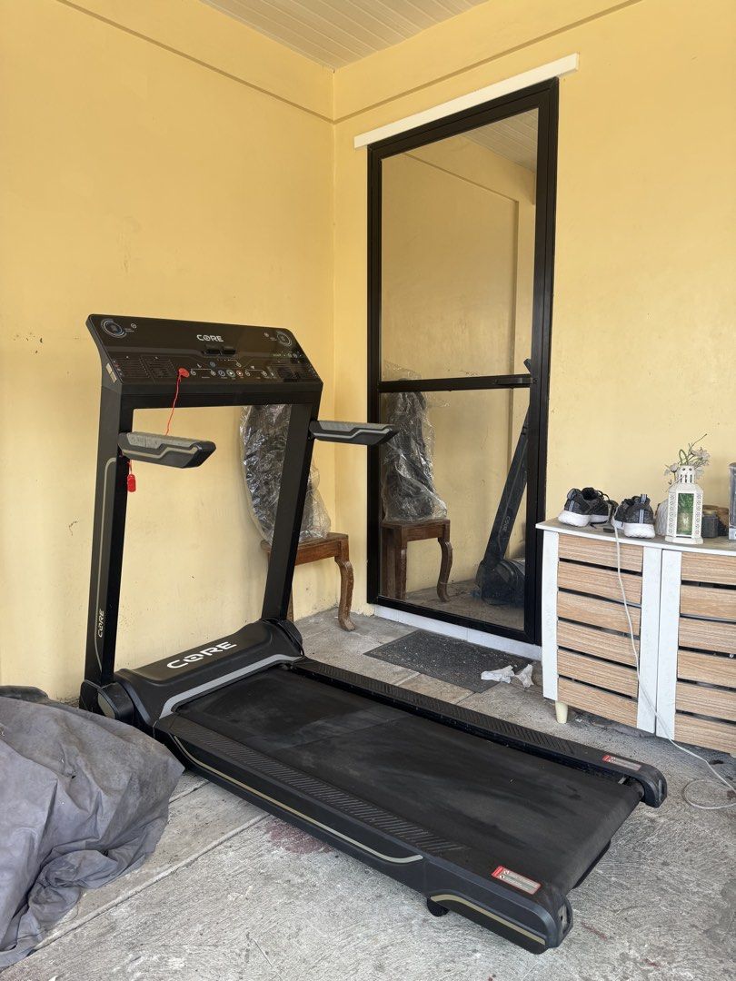 CORE iWalk Treadmill (Category: Cardio & Fitness Machines) located in Bacoor. Submitted by iampaulineeee (Listing ID 1468585226, Image 1). Description: - Brand/Model: CORE iWalk Treadmill - Color: Black and Grey - Features: Digital display (speed, inclination, programs), built-in speakers, and heart-rate grip sensors - Safety: Includes safety stop key with red cord - Design: Foldable space-saving design for easy upright storage - Condition: Norma