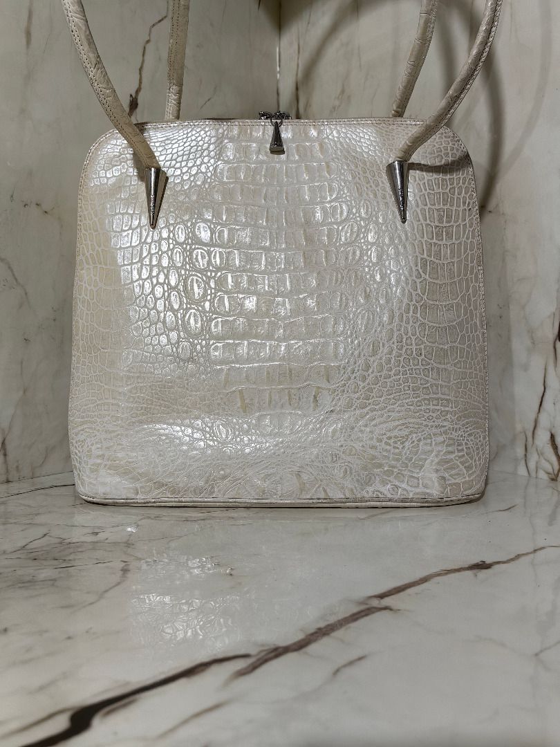 Cream Crocodile Leather Shoulder Bag (Category: Shoulder Bags) located in Tarlac. Submitted by jeremiah.curator.2026 (Listing ID 1468505569, Image 1). Description: - Color: Cream Crocodile Leather - Design: Structured shape with a flat bottom base - Straps: Dual shoulder straps featuring unique silver cone hardware accents - Closure: Secure top zip closure with cute tiny cone silver zipper pulls - Storage: Includes a convenient exterior back zipp
