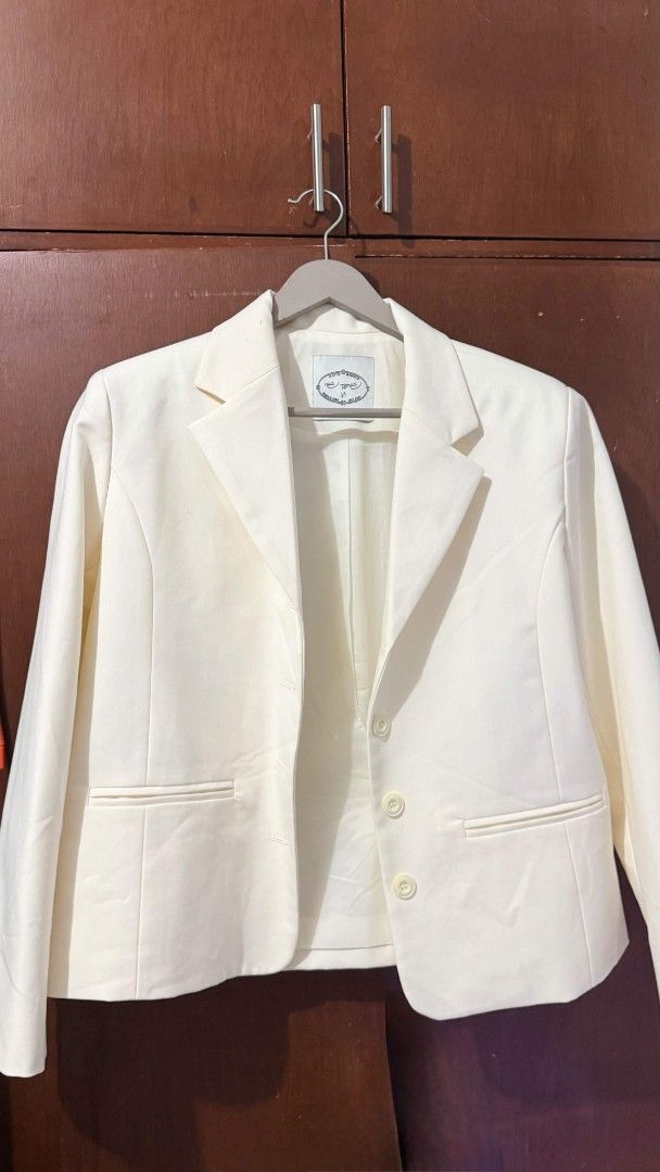 Cream white blazer with three buttons size M (Category: Coats, Jackets and Outerwear) located in Pasig City. Submitted by 35th.store (Listing ID 1468523642, Image 3). Description: - Color: Cream White - Size: M (with clean interior lining and inner tag) - Design: Notch lapel collar, three-button front closure, structured shoulders, and long sleeves - Pockets: Dual welt pockets at the front - Style: Neutral solid color, highly versatile for workwe
