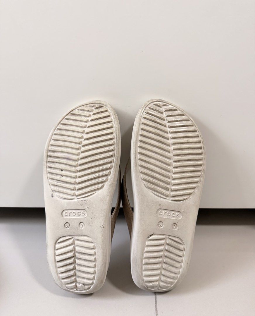 Crocs Glitter Thong Sandals Size W7 (Category: Slippers and slides) located in Quezon City. Submitted by eya_preloved (Listing ID 1468580380, Image 3). Description: - Brand: Crocs - Style: Platform flip-flops - Color: White with champagne gold sparkly straps - Size: Women's 7 - Features: Super lightweight foam footbed with textured grip - Condition: Clean footbeds, minor wear on bottom treads from brief outdoor use - Perfect for: Summer outings a