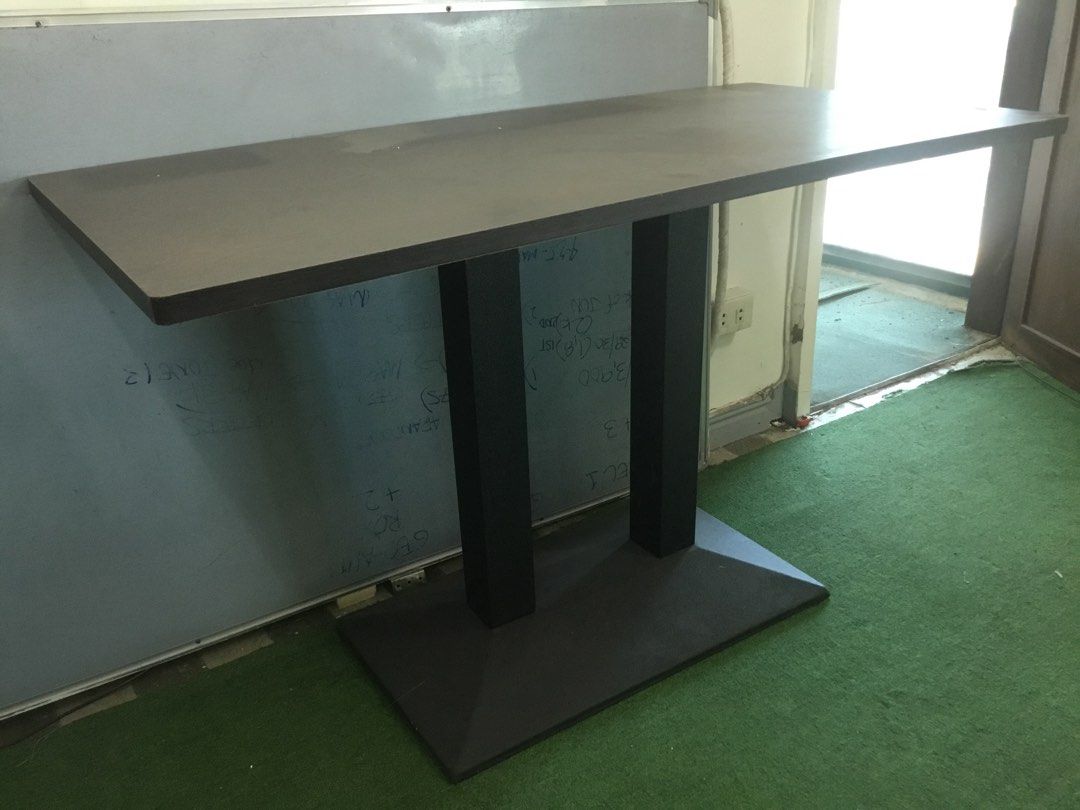 Dark Wood Rectangular Table with Double Black Pillar Base (Category: Tables & Sets) located in Manila. Submitted by roberto.enriquez (Listing ID 1468689979, Image 1). Description: - Dark brown rectangular wooden tabletop with a natural wood grain pattern - Supported by sturdy black vertical pillars and a wide base plate - Versatile design suitable for use as a dining table or office desk - Clean surfaces with minimal signs of wear - Dismantles ea