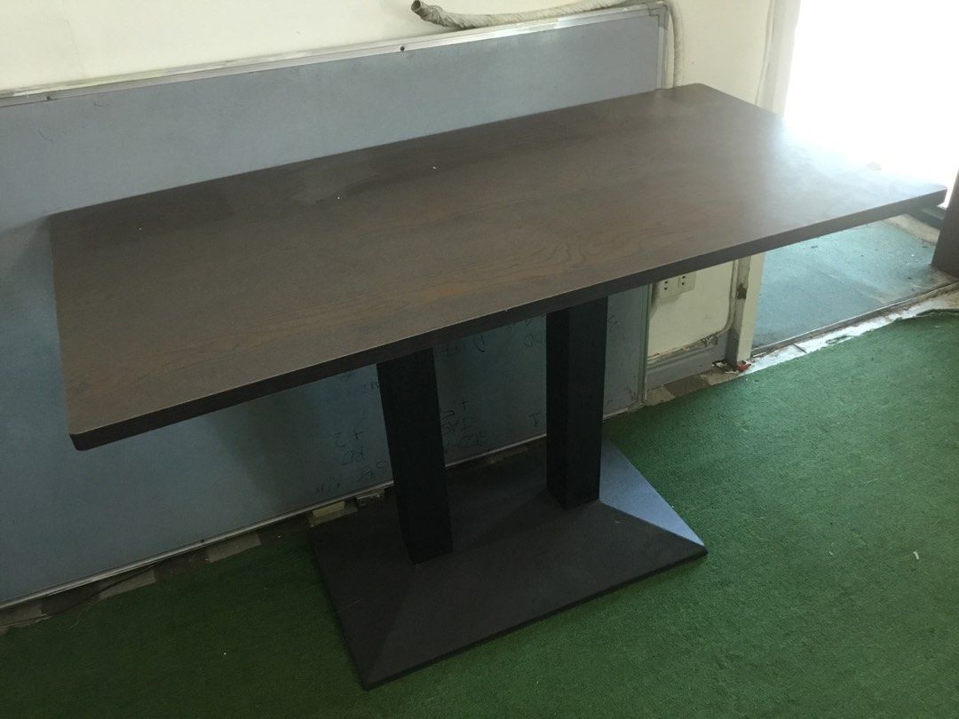 Dark Wood Rectangular Table with Double Black Pillar Base (Category: Tables & Sets) located in Manila. Submitted by roberto.enriquez (Listing ID 1468689979, Image 2). Description: - Dark brown rectangular wooden tabletop with a natural wood grain pattern - Supported by sturdy black vertical pillars and a wide base plate - Versatile design suitable for use as a dining table or office desk - Clean surfaces with minimal signs of wear - Dismantles ea