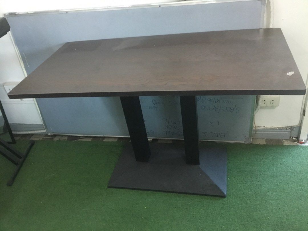 Dark Wood Rectangular Table with Double Black Pillar Base (Category: Tables & Sets) located in Manila. Submitted by roberto.enriquez (Listing ID 1468689979, Image 3). Description: - Dark brown rectangular wooden tabletop with a natural wood grain pattern - Supported by sturdy black vertical pillars and a wide base plate - Versatile design suitable for use as a dining table or office desk - Clean surfaces with minimal signs of wear - Dismantles ea
