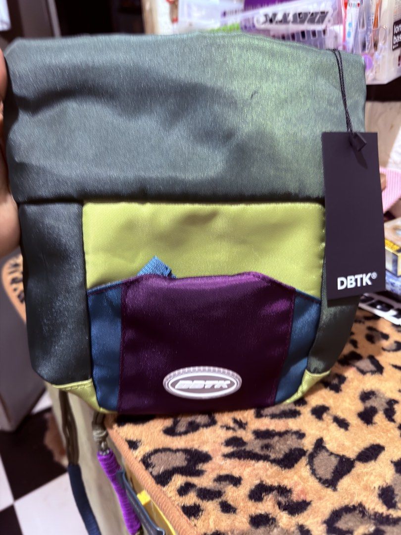 DBTK Colorblock Crossbody Bag (Category: Cross-body Bags) located in Quezon City. Submitted by auspv_collections (Listing ID 1468619952, Image 3). Description: - Brand: DBTK - Design: Colorblock (Olive Green, Blue, Yellow, Purple) - Compartments: Main zip compartment and front pocket with woven logo label - Strap: Detachable paracord-style strap with multi-colored wrapped sections - Condition: Brand new with hangtag attached - Perfect for daily s