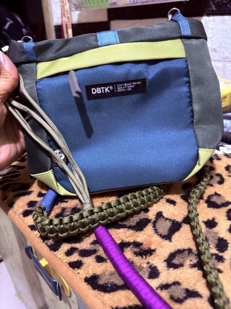 DBTK Colorblock Crossbody Bag (Category: Cross-body Bags) located in Quezon City. Submitted by auspv_collections (Listing ID 1468619952, Image 2). Description: - Brand: DBTK - Design: Colorblock (Olive Green, Blue, Yellow, Purple) - Compartments: Main zip compartment and front pocket with woven logo label - Strap: Detachable paracord-style strap with multi-colored wrapped sections - Condition: Brand new with hangtag attached - Perfect for daily s