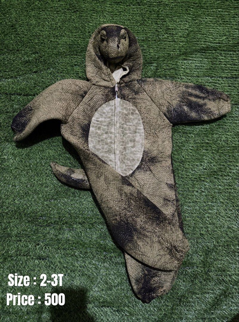 Dinosaur Costume for Toddlers Size 2-3T (Category: Babies & Kids Fashion) located in San Fernando. Submitted by InvisibleMe (Listing ID 1468709115, Image 1). Description: - Size: 2-3T toddler - Design: Realistic green and black reptile scale texture with a contrasting light beige belly panel - Features: Attached dinosaur head hood and a fun padded tail in the back - Convenience: Full front zipper closure for quick and easy dressing - Perfect for: