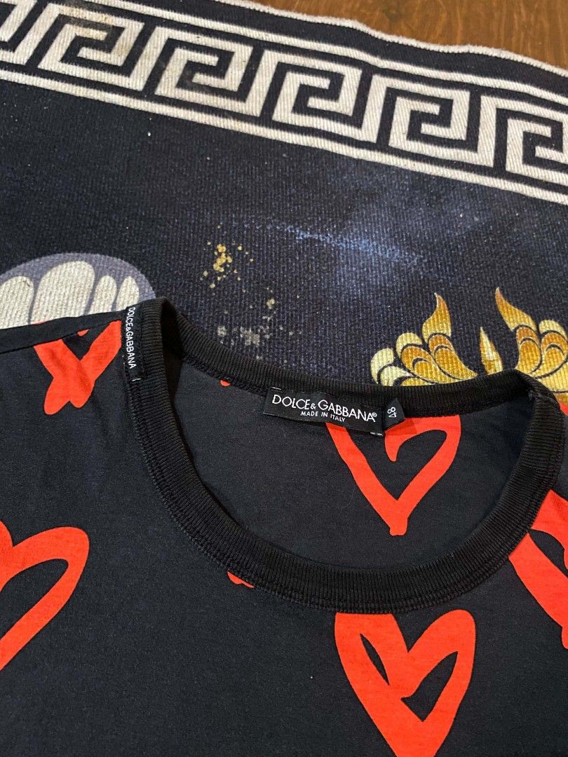 Dolce & Gabbana (Category: Shirts) located in Manila. Submitted by thrift_sta.20 (Listing ID 1468568853, Image 2). Description: - Brand: Dolce & Gabbana - Color/Design: Black with all-over red heart print - Details: Short sleeves, crew neck with black ribbed collar, Made in Italy label - Size: 48 - Condition: Clean fabric with clear, vibrant print throughout.