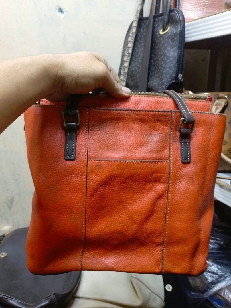 Dooney & Bourke Orange Leather Tote Bag (Category: Luxury Bags & Wallets) located in Manila. Submitted by dei03_diz (Listing ID 1468543278, Image 2). Description: - Brand/Model: Dooney & Bourke Tote Bag - Color: Bright orange pebble leather with vibrant red interior - Hardware: Gold-tone metal hardware with front exterior logo plaque - Straps: Comfortable double shoulder straps - Closure: Secure top zip closure - Interior: Red fabric lining featu