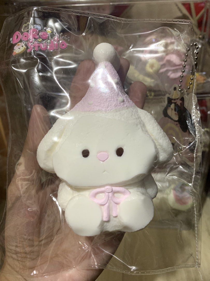 Doro Studio White Bunny Party Hat Squishy Toy (Category: Plushies & Soft Toys) located in Valenzuela. Submitted by cielittlestuff (Listing ID 1468541439, Image 1). Description: - Brand: Doro Studio - Item: White bunny squishy - Design: Wearing a cute pink party hat and matching ribbon on the front - Material: Soft foam for a satisfying slow-rise experience - Condition: Brand new, sealed in original clear plastic packaging - Perfect for gifts, str