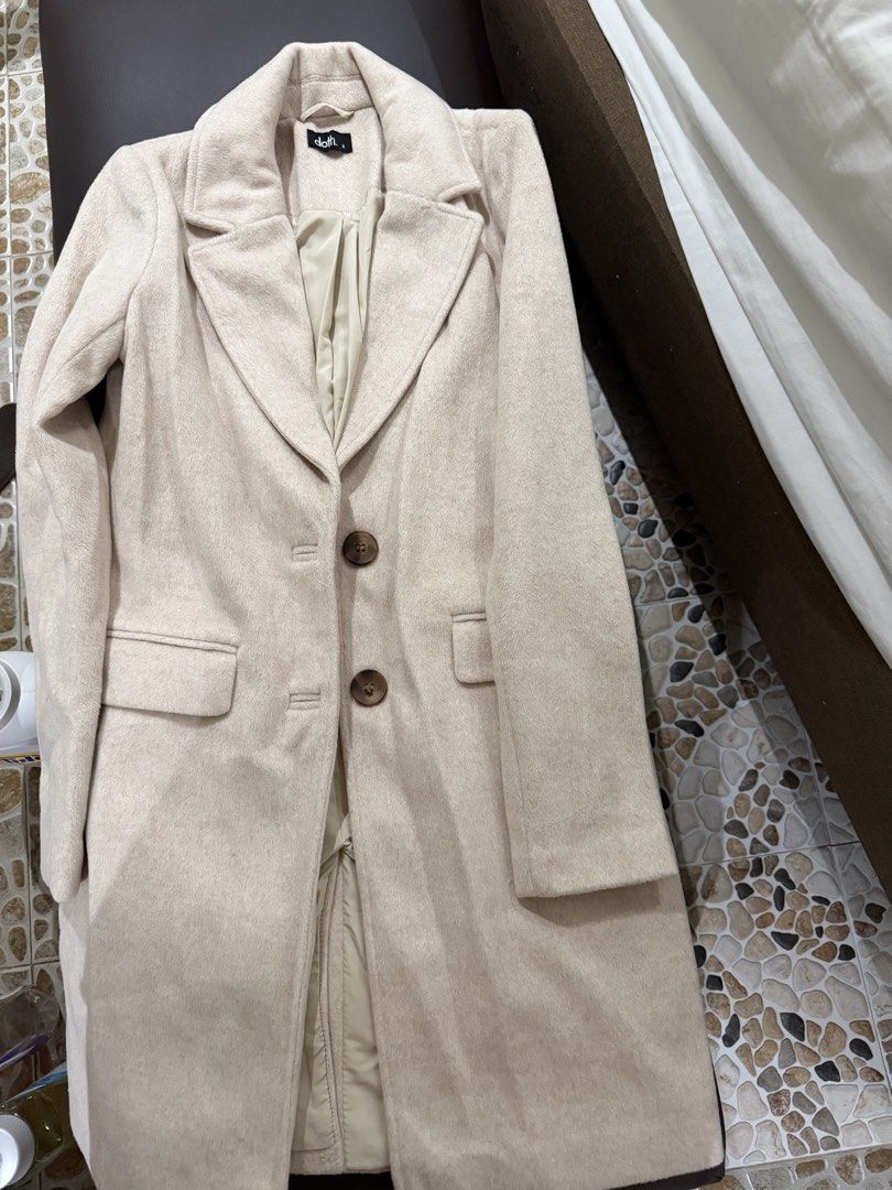 Dotti Beige Wool Coat Size 8 (Category: Coats, Jackets and Outerwear) located in Quezon City. Submitted by kimioutlet (Listing ID 1468607206, Image 2). Description: - Brand/Model: Dotti Beige Wool Coat - Size: 8 - Design: Classic longline cut with structured lapels - Closure: Two brown buttons down the front - Pockets: Deep pockets on both sides - Interior: Fully lined for extra warmth - Style: Neutral cream shade, perfect for easy layering in co