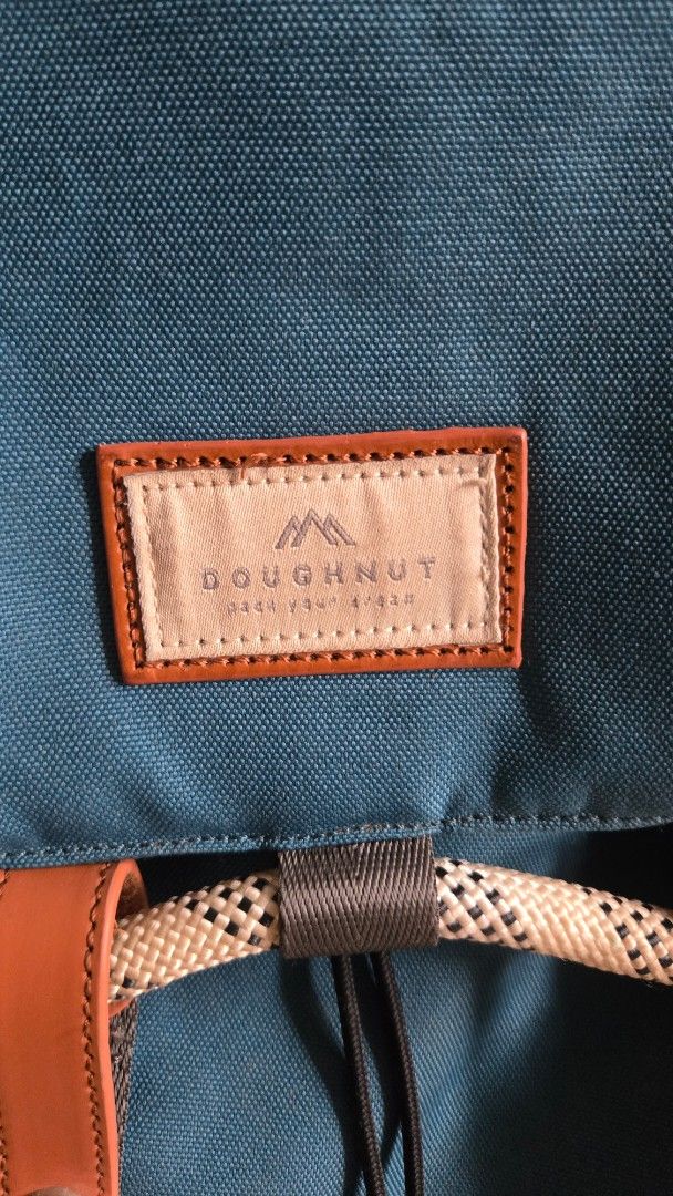 Doughnut Blue Canvas Backpack with Brown Leather Accents (Category: Backpacks) located in Mandaluyong City. Submitted by ohayouclub (Listing ID 1468529268, Image 2). Description: - Brand/Model: Doughnut Backpack in Dark Teal Blue - Material & Accents: Durable canvas with brown leather and rope details - Closure: Drawstring main closure with secure buckle straps - Comfort & Carry: Padded shoulder straps equipped with metal D-rings - Storage: Conve