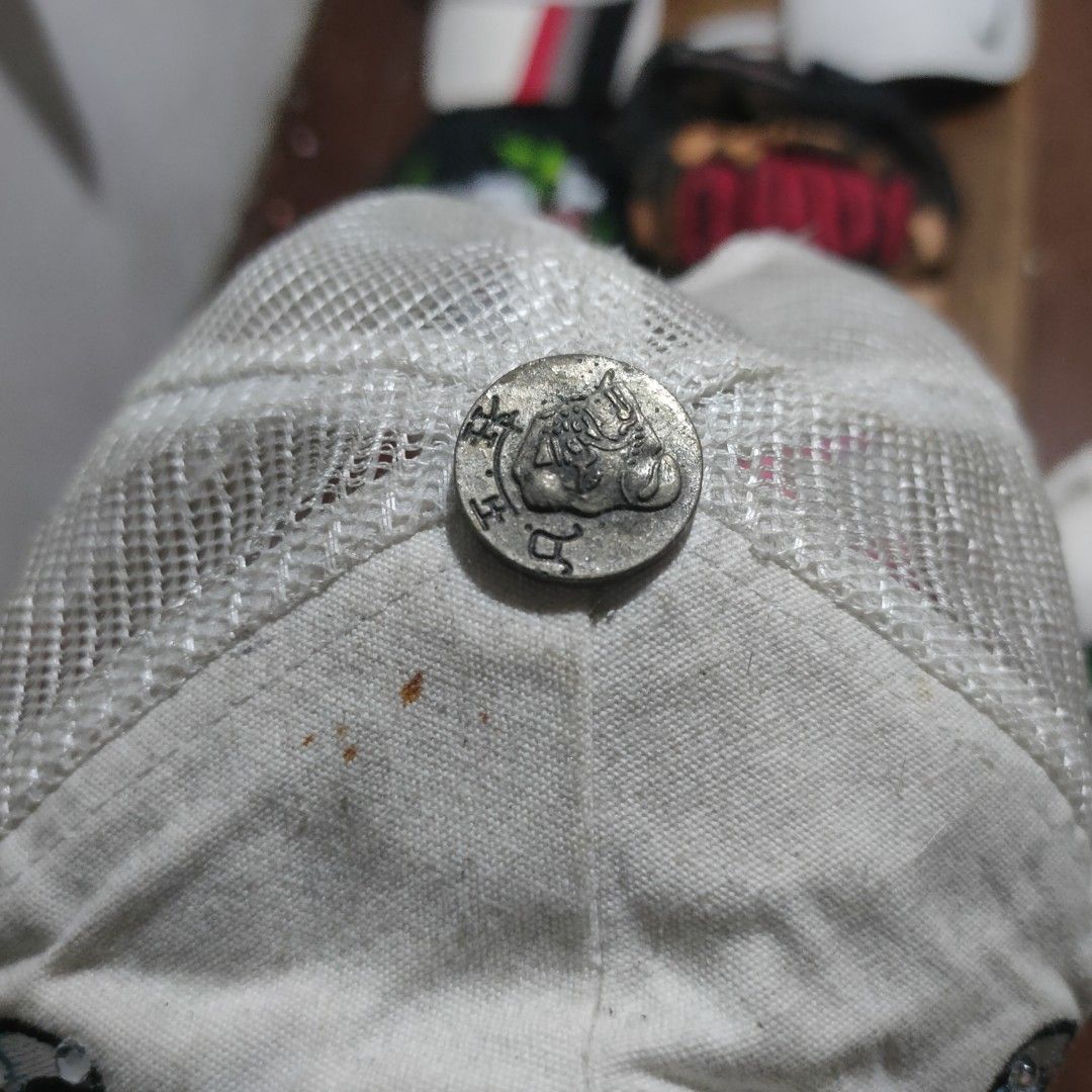 Ed Hardy Trucker Hat White Skull Racing Flags (Category: Caps & Hats) located in Taguig. Submitted by actualizeboutique (Listing ID 1468524511, Image 2). Description: - Brand: Ed Hardy - Style: White trucker hat with adjustable plastic snapback closure - Design: Rhinestone-embellished skull wearing a racing helmet, checkered flags, and pistons, with embroidered Ed Hardy script on the brim - Material/Backing: White mesh back panels - Condition: Go