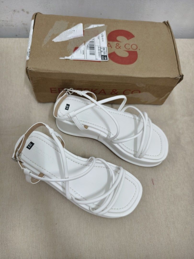 Erosska & Co. White Platform Sandals Size 37 (Category: Sandals) located in Angeles City. Submitted by measaliman02351 (Listing ID 1468504611, Image 2). Description: - Brand: Erosska & Co. - Size: 37 (marked on insole) - Color: White - Style: Strappy platform sandals with thin criss-cross straps and ankle buckle closure - Heel: Chunky wedge heel and thick sole - Inclusions: Comes with original branded shoe box - Condition: Excellent/Ready to wear