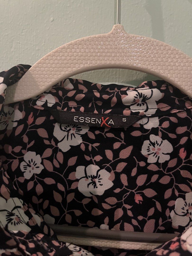EssenXer Floral Long Sleeve Button Down Blouse Size S (Category: Longsleeves) located in Pasig City. Submitted by fmc828 (Listing ID 1468508364, Image 2). Description: - Brand: EssenXer - Style: Button-down shirt with pointed collar and curved hem - Design: Black base with a vibrant white and pink floral pattern - Fit & Size: Women's Small, lightweight fabric - Versatility: Perfect for both office wear and casual weekend outings - Condition: Grea