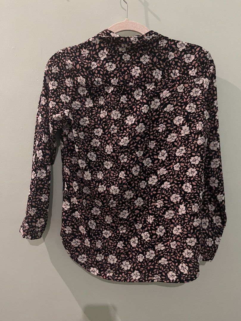 EssenXer Floral Long Sleeve Button Down Blouse Size S (Category: Longsleeves) located in Pasig City. Submitted by fmc828 (Listing ID 1468508364, Image 3). Description: - Brand: EssenXer - Style: Button-down shirt with pointed collar and curved hem - Design: Black base with a vibrant white and pink floral pattern - Fit & Size: Women's Small, lightweight fabric - Versatility: Perfect for both office wear and casual weekend outings - Condition: Grea
