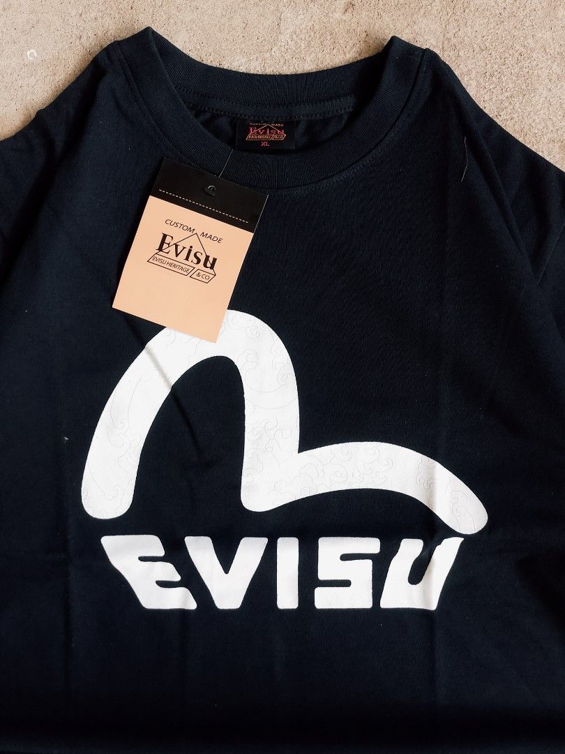 Evisu Black T-Shirt with Seagull Logo (Category: Tshirts & Polo Shirts ) located in Batangas. Submitted by rafstaywitstaff_11 (Listing ID 1468532432, Image 2). Description: - Brand: Evisu - Color: Black - Size: XL - Condition: Brand new with original hangtag attached - Design: Large white seagull graphic on the chest with a subtle wave pattern - Details: Features Evisu Heritage & Co branding tag sewn near the bottom hem and inside the collar - 10