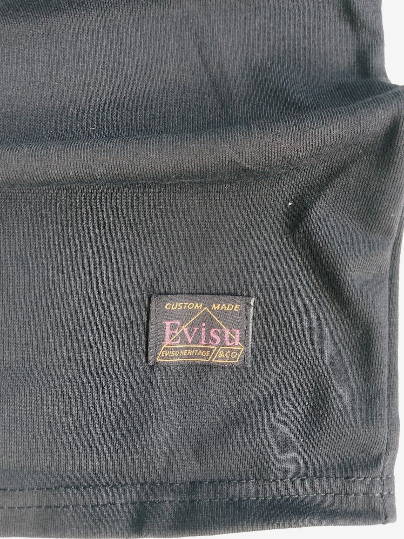 Evisu Black T-Shirt with Seagull Logo (Category: Tshirts & Polo Shirts ) located in Batangas. Submitted by rafstaywitstaff_11 (Listing ID 1468532432, Image 3). Description: - Brand: Evisu - Color: Black - Size: XL - Condition: Brand new with original hangtag attached - Design: Large white seagull graphic on the chest with a subtle wave pattern - Details: Features Evisu Heritage & Co branding tag sewn near the bottom hem and inside the collar - 10