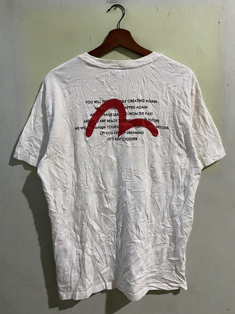 Evisu Craft With Pride White T-shirt (Category: Tshirts & Polo Shirts ) located in Pandi. Submitted by nasya_thrift_collection2023 (Listing ID 1468594959, Image 2). Description: - Brand: Evisu - Color: White with black front chest text ("Craft with Pride") - Design: Large red Evisu graphic with typography on the back - Details: Black neck tag with white lettering, standard crew neck, and short sleeves - Authenticity: Korean wash tag with QR code 