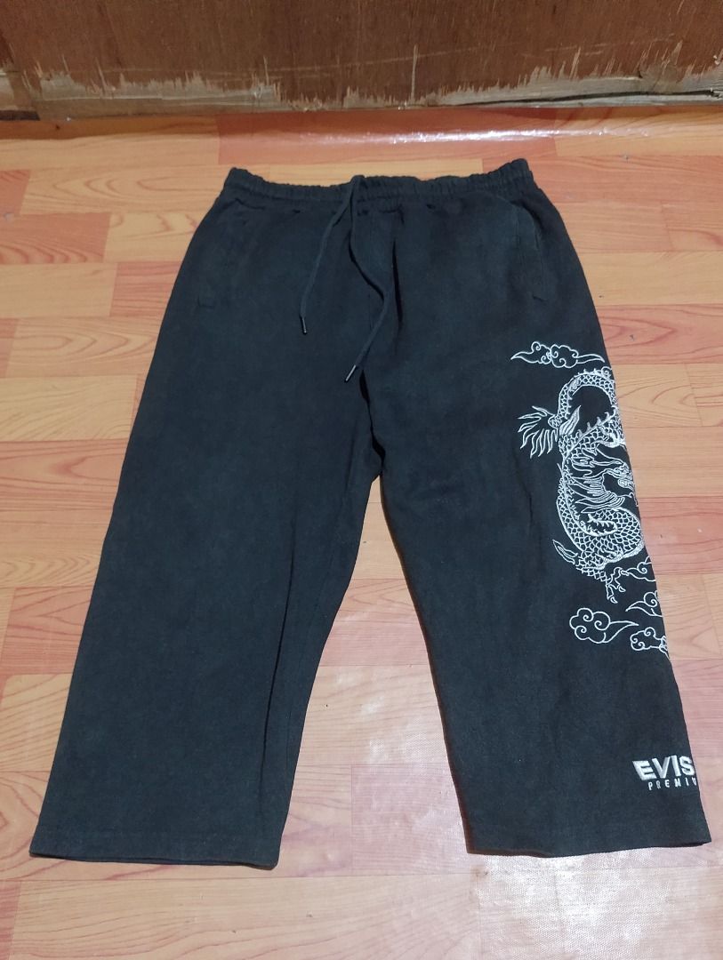 Evisu Premium Black Dragon Sweatpants Size 110 (Category: Joggers) located in Cavite. Submitted by marvzclothing (Listing ID 1468611896, Image 1). Description: - Brand: Evisu Premium - Model Code: ES2MZP702 - Color: Black - Waist: 32-34 - Material: 65% Cotton, 35% Polyester - Design: Large white embroidered dragon and cloud graphics on the left leg with Evisu text near the hem - Features: Elastic waistband with adjustable drawstring, back pockets