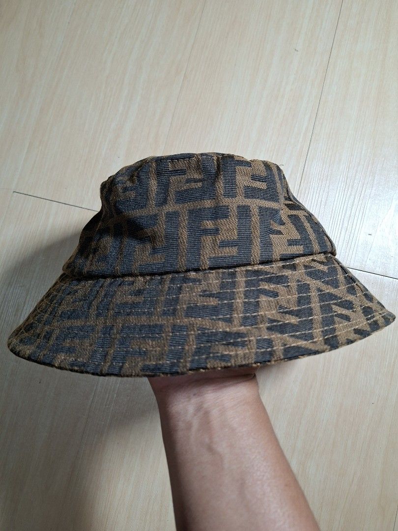 Fendi Zucca FF Logo Brown Bucket Hat (Category: Caps & Hats) located in Baguio. Submitted by restyrille77846 (Listing ID 1468643639, Image 2). Description: - Brand: Fendi - Design: Classic brown and black FF Zucca logo print - Interior: Dark lining with stitched Fendi Roma tag - Features: Structured brim, lightweight fabric - Style: Ultimate streetwear accessory.