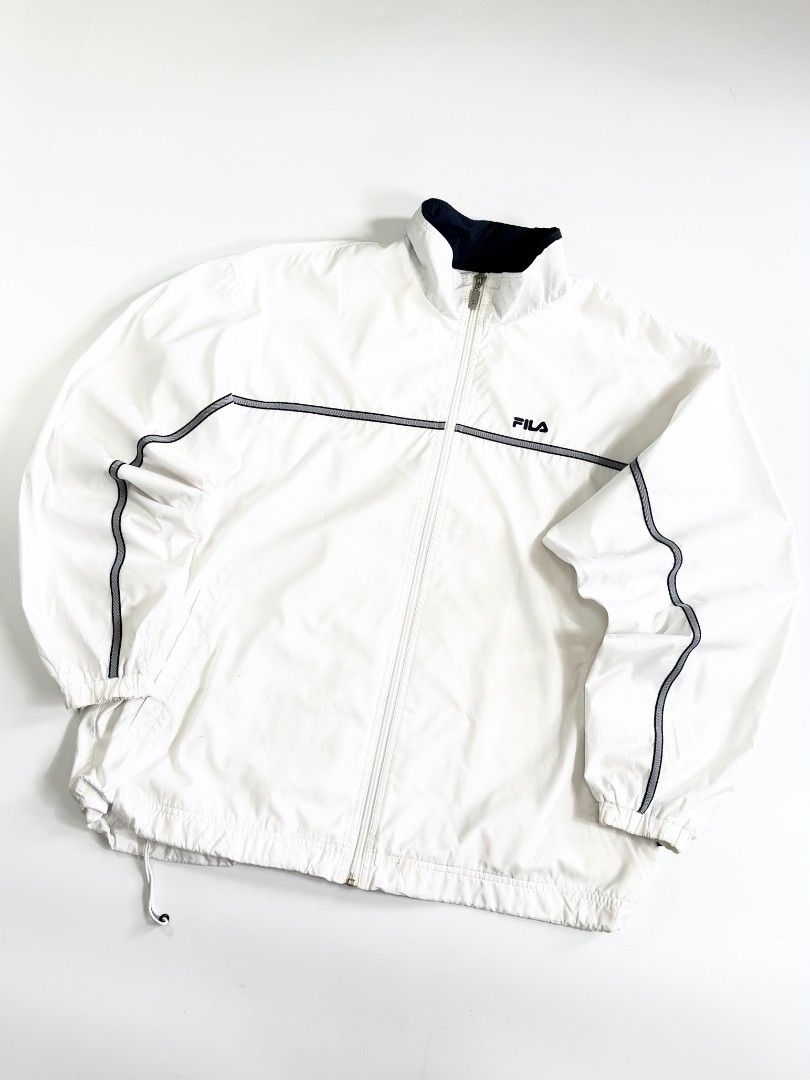 FILA (Category: Coats, Jackets and Outerwear) located in Valenzuela. Submitted by veriez_gems (Listing ID 1468626188, Image 3). Description: Vintage Vibe: Clean 90s Style Fila Windbreaker! Style: Men's Full-Zip Lightweight Windbreaker Jacket Color: Bright White with contrasting dark Navy blue collar lining Authenticity: Features the iconic FILA logo embroidered on the right chest in navy/red Authentic branded zipper pull Includes original FILA ne