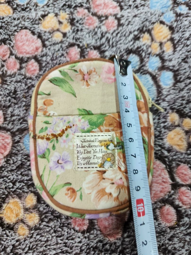 Floral pattern fabric coin purse with zip closure (Category: Purses & Pouches) located in San Leonardo. Submitted by burgossanleonardo.12345 (Listing ID 1468647735, Image 3). Description: - Vintage floral fabric coin purse in earthy beige, green, and brown tones - Measures approximately 11 cm tall for a compact, everyday fit - Secure top zip closure to keep your items safe - Front slip pocket with a charming sewn-on label - Fully lined with a pre