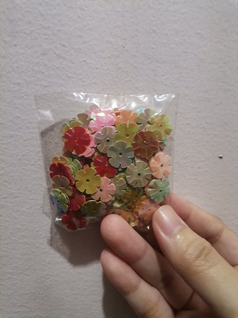 Flower and heart sequins craft supplies (Category: Craft Supplies & Tools) located in Makati City. Submitted by kookybearsstuff (Listing ID 1468621013, Image 1). Description: - 3 bags of loose sequins for DIY crafts and sewing projects - Pack 1 and 2: Multicolored flower-shaped sequins (pink, red, yellow, green) - Pack 3: Green and dark heart-shaped sequins - Conveniently packed in clear plastic bags.