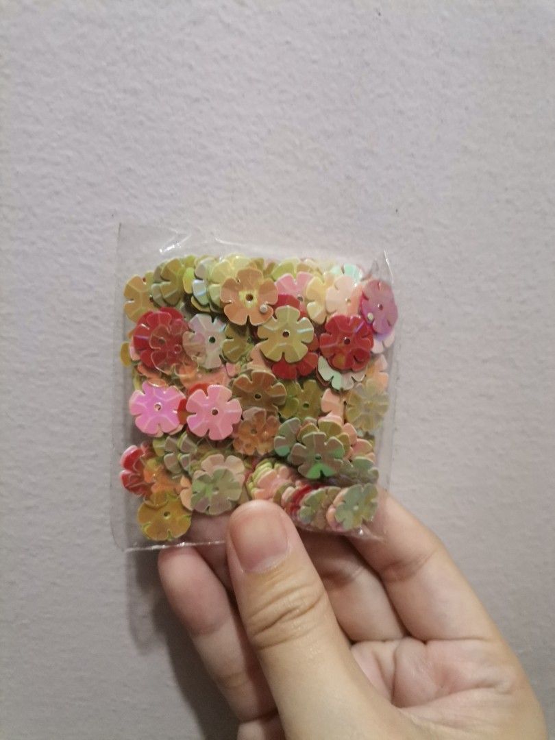 Flower and heart sequins craft supplies (Category: Craft Supplies & Tools) located in Makati City. Submitted by kookybearsstuff (Listing ID 1468621013, Image 2). Description: - 3 bags of loose sequins for DIY crafts and sewing projects - Pack 1 and 2: Multicolored flower-shaped sequins (pink, red, yellow, green) - Pack 3: Green and dark heart-shaped sequins - Conveniently packed in clear plastic bags.