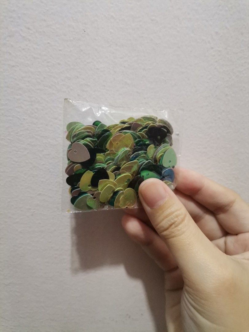 Flower and heart sequins craft supplies (Category: Craft Supplies & Tools) located in Makati City. Submitted by kookybearsstuff (Listing ID 1468621013, Image 3). Description: - 3 bags of loose sequins for DIY crafts and sewing projects - Pack 1 and 2: Multicolored flower-shaped sequins (pink, red, yellow, green) - Pack 3: Green and dark heart-shaped sequins - Conveniently packed in clear plastic bags.