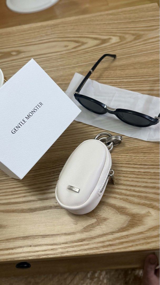 Foldable Gentle Monster Sunglasses with pouch (Category: Sunglasses & Eyewear) located in Paranaque City. Submitted by atbp2022 (Listing ID 1468574248, Image 1). Description: - Brand: Gentle Monster - Style: Ivy, Trendy oval shape with black frames and dark lenses - Condition: brand new, worn only once for a quick photo - Inclusions: Original white protective case with keyring attachment and white branded packaging box - Perfect for daily wear an