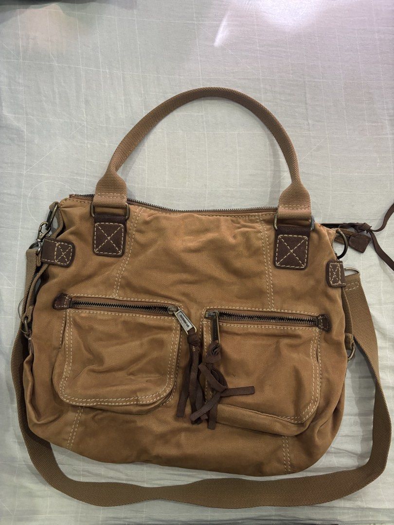 Fossil Brown Canvas Crossbody Shoulder Bag (Category: Cross-body Bags) located in Floridablanca. Submitted by jmvbautista (Listing ID 1468542686, Image 2). Description: - Brand: Fossil - Material: Durable brown canvas with premium leather trim and antique bronze hardware - Versatile Carry: Includes dual top handles and a detachable, adjustable crossbody strap - Exterior Storage: Dual front zippered pockets, front slip pocket, and iconic Fossil 19