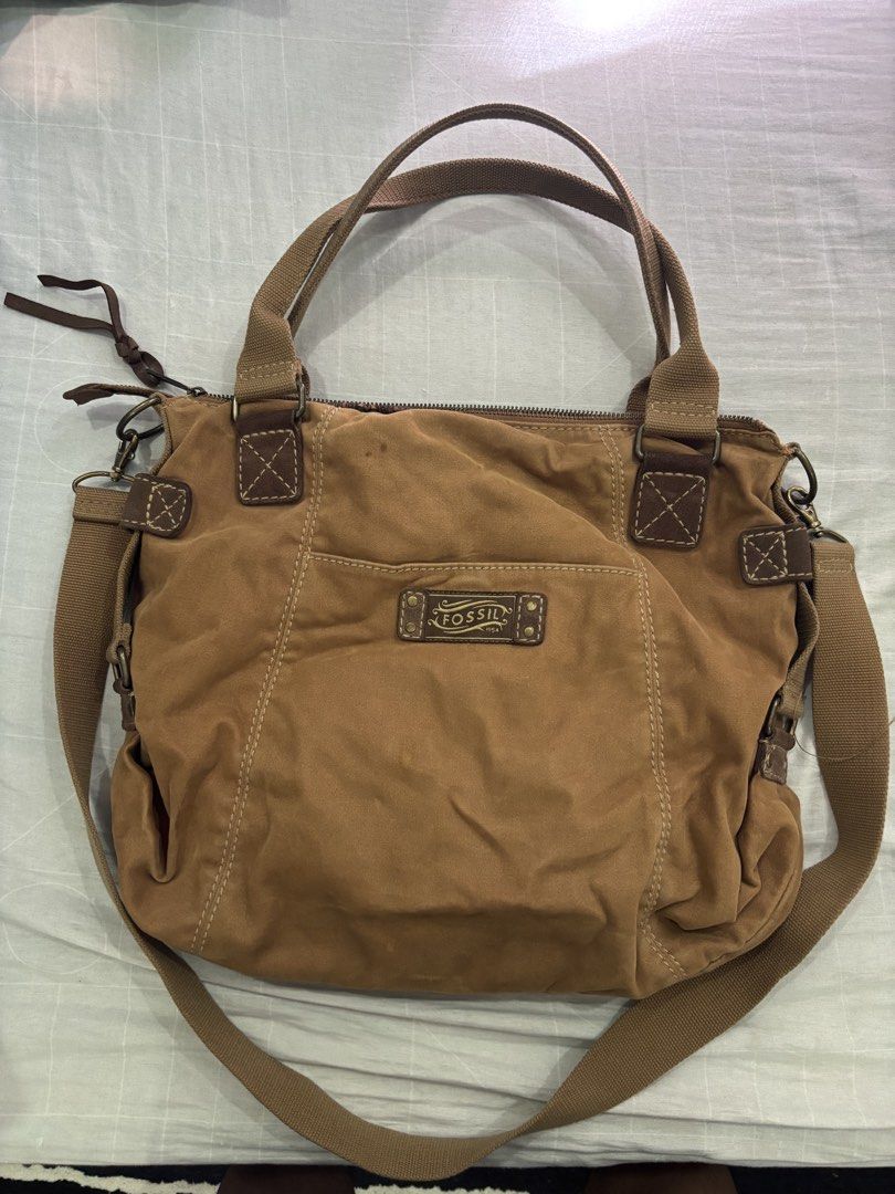 Fossil Brown Canvas Crossbody Shoulder Bag (Category: Cross-body Bags) located in Floridablanca. Submitted by jmvbautista (Listing ID 1468542686, Image 1). Description: - Brand: Fossil - Material: Durable brown canvas with premium leather trim and antique bronze hardware - Versatile Carry: Includes dual top handles and a detachable, adjustable crossbody strap - Exterior Storage: Dual front zippered pockets, front slip pocket, and iconic Fossil 19
