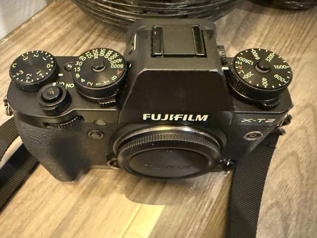 Fujifilm X-T2 Mirrorless Camera with Strap (Category: Cameras) located in Quezon City. Submitted by jubbyjenkins112892 (Listing ID 1468666544, Image 3). Description: - Fujifilm X-T2 body (Black) with strap - Includes a kit of three lenses with caps attached - Classic dial layout featuring shutter speed, ISO, and exposure compensation dials - Body is mostly clean overall with minor scuffs around the edges - Rubber grip is fully intact Model: Fujif