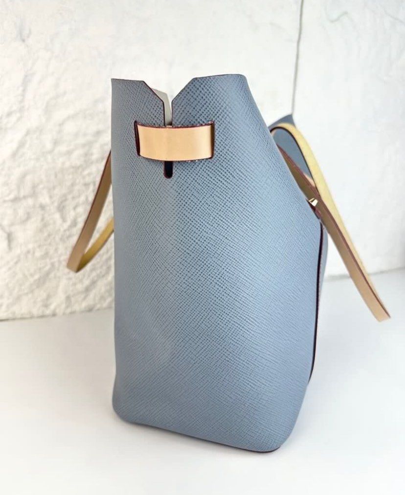 Furla Blue Leather Tote Bag (Category: Tote Bags) located in Cavite. Submitted by honeyjmo (Listing ID 1468573393, Image 3). Description: - Brand: Furla - Material: Premium Saffiano leather in light blue - Straps & Hardware: Dual tan shoulder straps with gold-tone studs - Design: Structured rectangular base with front central lock detail - Condition: Pristine exterior and clean interior - Capacity: Spacious enough for daily essentials, work items