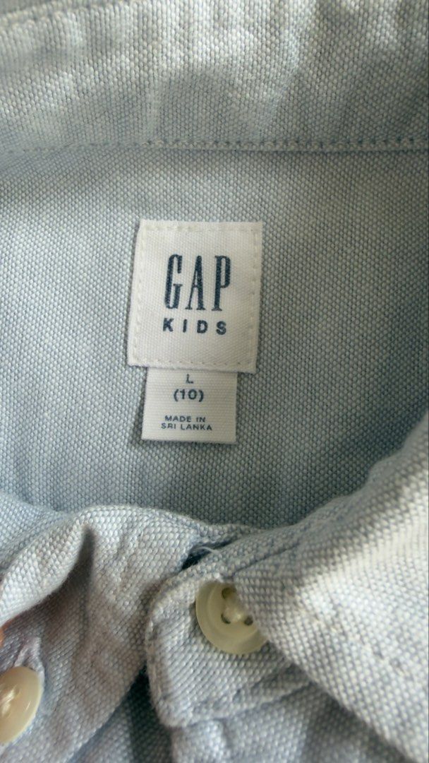 Gap Kids Light Blue Button-Down Shirt Size L 10 (Category: Babies & Kids Fashion) located in Cainta. Submitted by sixteenfive29 (Listing ID 1468602843, Image 2). Description: Super nice in actual Light blue - Brand: Gap Kids - Color: Light Blue - Size: L (fits around age 10) - Design: Classic collar, long sleeves, front button closure, and a sweet embroidered bear on the single chest pocket - Material & Origin: Made in Sri Lanka - Perfect for: Sc